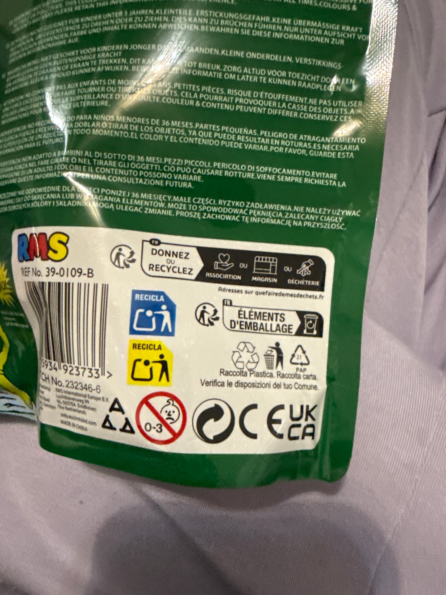 Green packaging with multiple labels and symbols on a light gray background